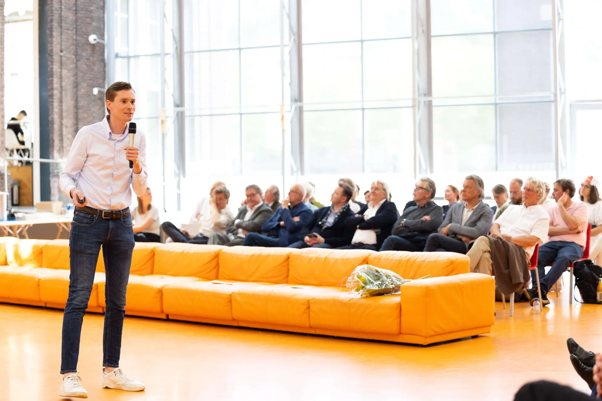 Een spreker van Factor10 geeft een presentatie voor een zaal vol vakgenoten.